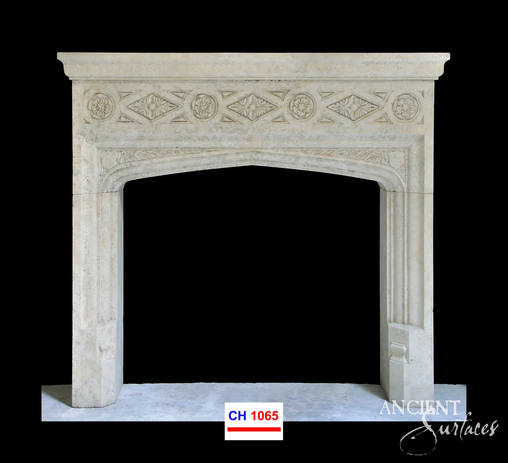Hand-carved reclaimed limestone fireplace mantel showing its rosette frieze and Tudor-arch detailing